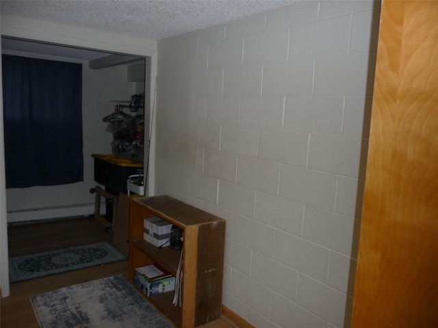 3115 8th Ave N, Great Falls, MT 59401 - corridor with baseboard heating, a textured ceiling, and concrete block wall