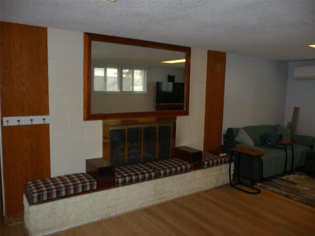 3115 8th Ave N, Great Falls, MT 59401 - living area with an AC wall unit, wood finished floors, a textured ceiling, and a glass covered fireplace