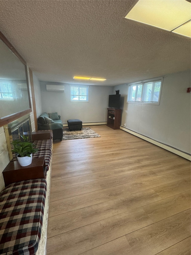 3115 8th Ave N, Great Falls, MT 59401 - living room featuring baseboard heating, wood finished floors, a textured ceiling, a wall mounted air conditioner, and a glass covered fireplace
