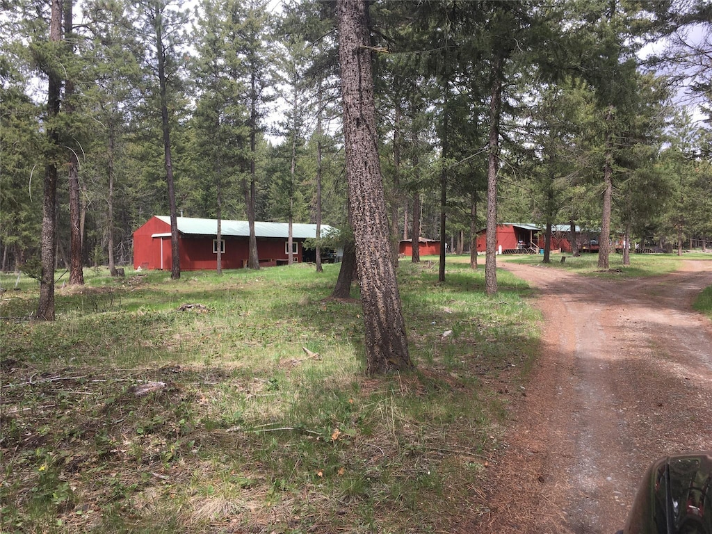 602 Upper Lynch Creek Rd, Plains, MT 59859 - view of yard with a wooded view, driveway, an outdoor structure, and a pole building