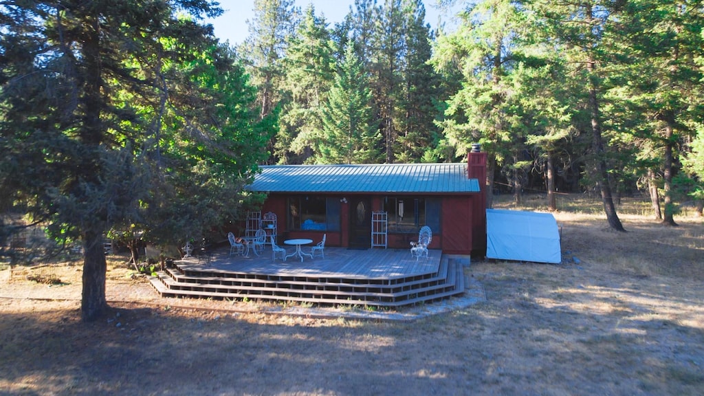 602 Upper Lynch Creek Rd, Plains, MT 59859 - view of front of home featuring a chimney, metal roof, and a view of trees