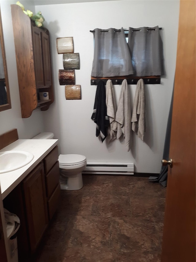 314 4th Ave NE, Cut Bank, MT 59427 - bathroom featuring a baseboard radiator, vanity, toilet, and stone finish flooring