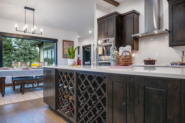 344 Chapman Ln, Bigfork, MT 59911 - kitchen with wall chimney exhaust hood, light wood finished floors, decorative light fixtures, dark brown cabinetry, and recessed lighting