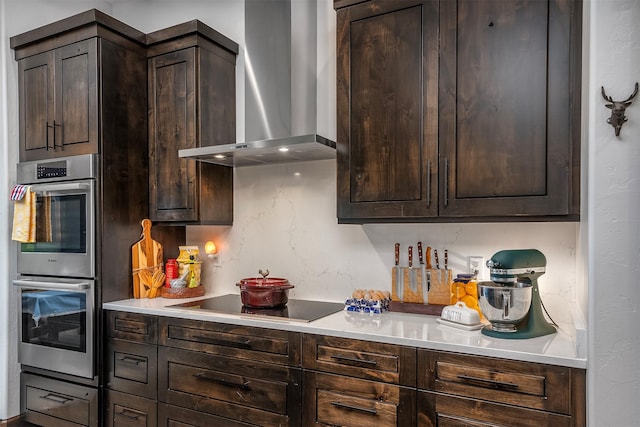 344 Chapman Ln, Bigfork, MT 59911 - kitchen featuring wall chimney range hood, black electric cooktop, stainless steel double oven, dark brown cabinets, and light countertops