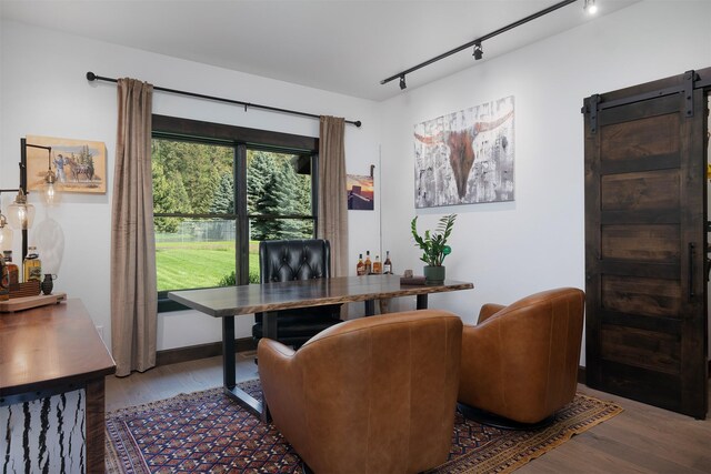 344 Chapman Ln, Bigfork, MT 59911 - home office featuring wood finished floors, rail lighting, and a barn door