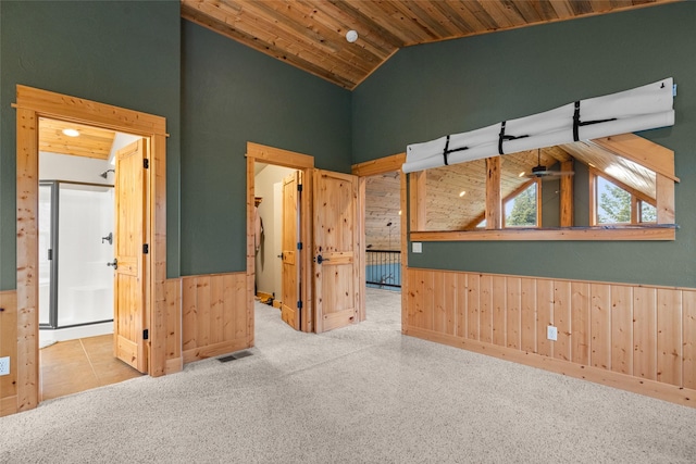 217 Forest Ridge Trl, Kila, MT 59920 - carpeted spare room with high vaulted ceiling, wood ceiling, wood walls, wainscoting, and ceiling fan