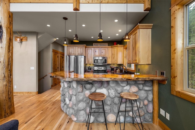 217 Forest Ridge Trl, Kila, MT 59920 - kitchen featuring appliances with stainless steel finishes, a sink, light wood-type flooring, a peninsula, and dark stone countertops