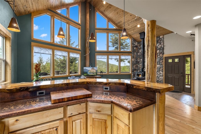 217 Forest Ridge Trl, Kila, MT 59920 - kitchen with a wood stove, high vaulted ceiling, wooden ceiling, light brown cabinetry, and pendant lighting