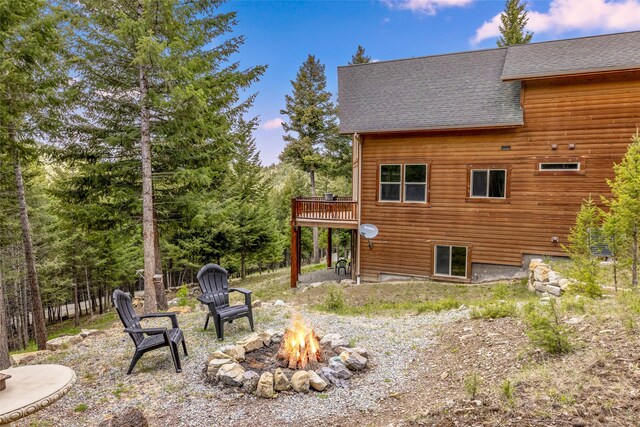 217 Forest Ridge Trl, Kila, MT 59920 - back of house with roof with shingles, an outdoor fire pit, and a wooden deck