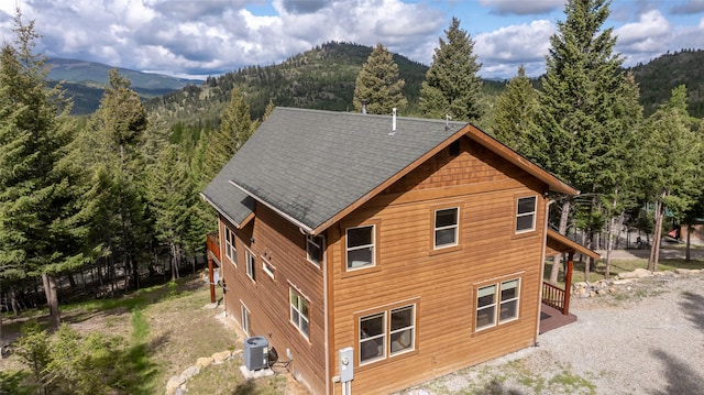 217 Forest Ridge Trl, Kila, MT 59920 - back of house featuring a forest view, a mountain view, and cooling unit