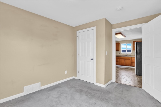 1721 13th Ave S, Great Falls, MT 59405 - unfurnished bedroom featuring freestanding refrigerator, a sink, carpet, and baseboards