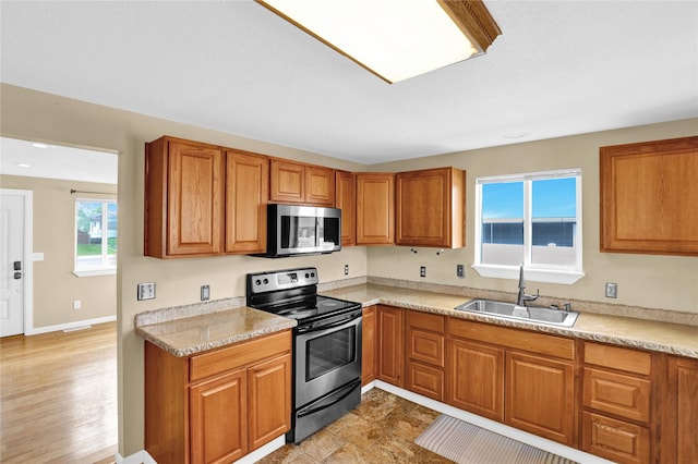 1721 13th Ave S, Great Falls, MT 59405 - kitchen featuring appliances with stainless steel finishes, a sink, brown cabinets, and light countertops