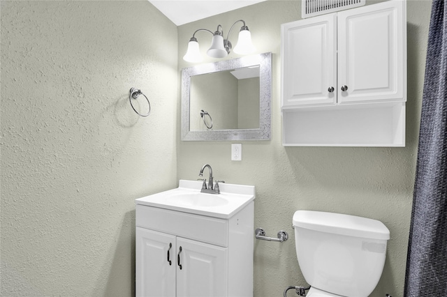 1721 13th Ave S, Great Falls, MT 59405 - bathroom featuring vanity, a textured wall, and toilet