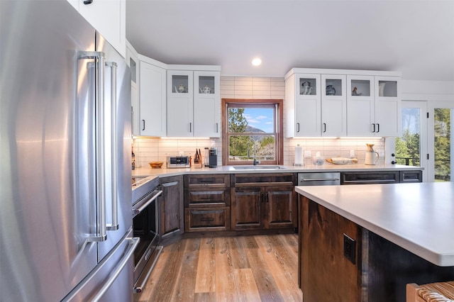 550 Talbot Rd, Columbia Falls, MT 59912 - kitchen featuring stainless steel appliances, a sink, light countertops, light wood-style floors, and dark brown cabinetry