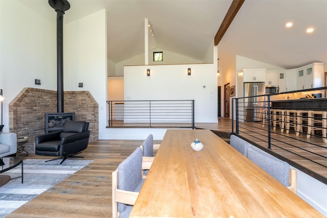 550 Talbot Rd, Columbia Falls, MT 59912 - dining area with a wood stove, wood finished floors, high vaulted ceiling, and beamed ceiling