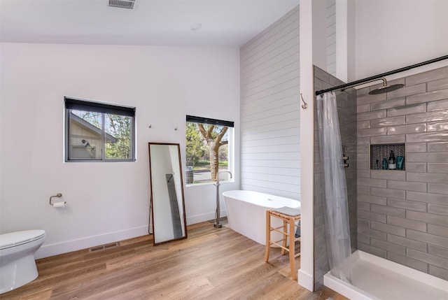 550 Talbot Rd, Columbia Falls, MT 59912 - bathroom featuring tiled shower, wood finished floors, toilet, a soaking tub, and baseboards