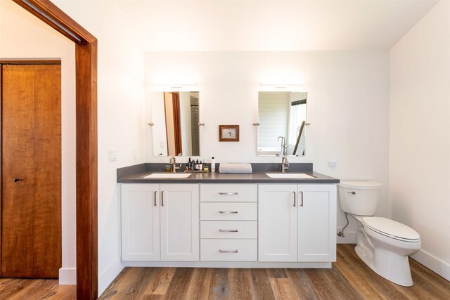 550 Talbot Rd, Columbia Falls, MT 59912 - bathroom with baseboards, double vanity, wood finished floors, and toilet