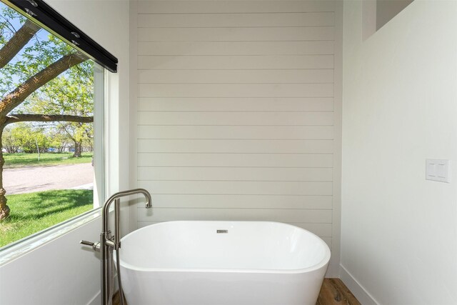 550 Talbot Rd, Columbia Falls, MT 59912 - bathroom with a soaking tub, wood walls, wood finished floors, and baseboards