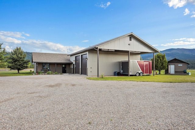 17 River Runs Ct, Plains, MT 59859 - view of front of home with a mountain view, a front yard, an outbuilding, a detached garage, and driveway
