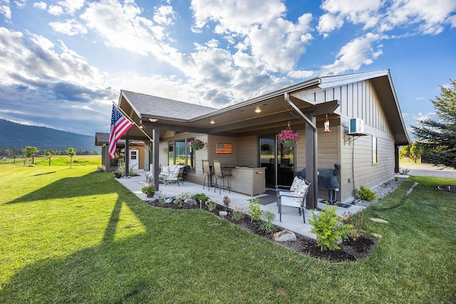 17 River Runs Ct, Plains, MT 59859 - rear view of property featuring a patio area, a lawn, and a mountain view