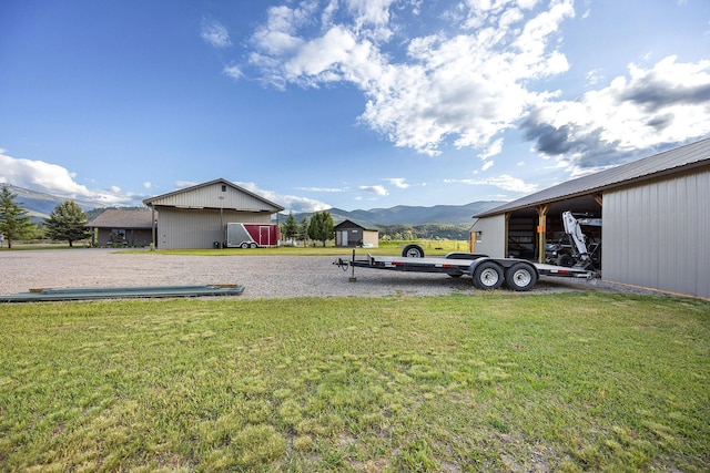 17 River Runs Ct, Plains, MT 59859 - view of green lawn featuring a mountain view, a pole building, and an outbuilding