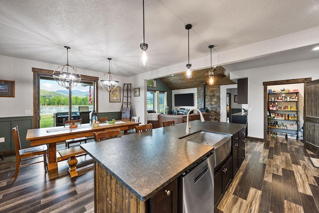 17 River Runs Ct, Plains, MT 59859 - kitchen featuring dishwasher, dark countertops, a textured ceiling, dark wood finished floors, and a center island with sink