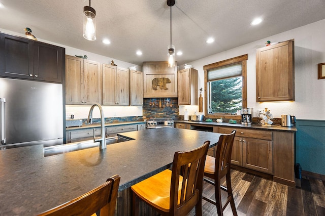 17 River Runs Ct, Plains, MT 59859 - kitchen featuring dark countertops, stainless steel appliances, dark wood-type flooring, a sink, and a textured ceiling