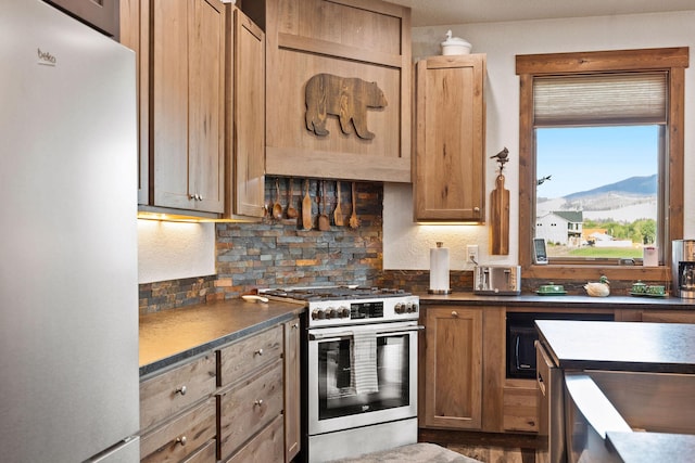 17 River Runs Ct, Plains, MT 59859 - kitchen featuring freestanding refrigerator, gas stove, dark countertops, decorative backsplash, and a mountain view