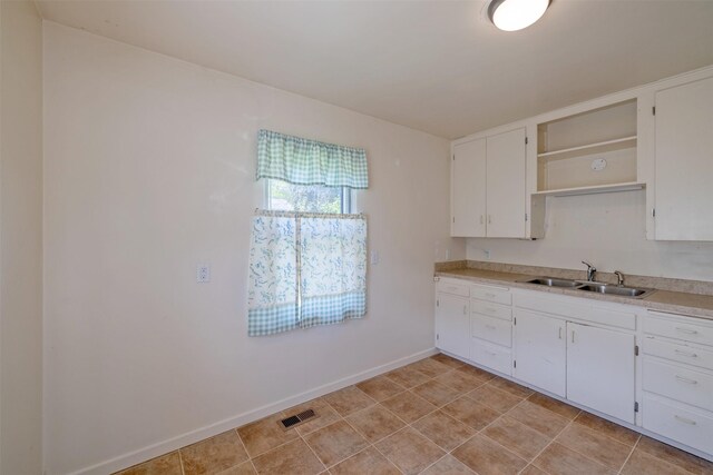 925 Hollins Ave, Helena, MT 59601 - kitchen with a sink, white cabinetry, light countertops, open shelves, and baseboards