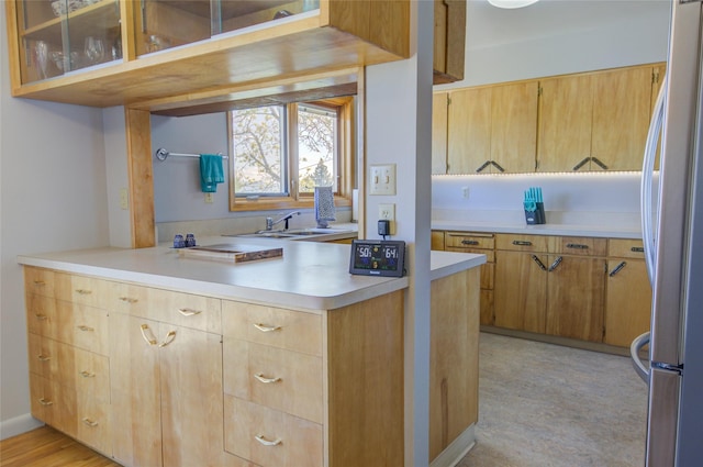1320 Flowerree St, Helena, MT 59601 - kitchen featuring freestanding refrigerator, light countertops, a peninsula, light brown cabinetry, and a sink