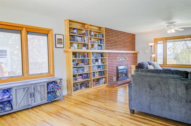 1320 Flowerree St, Helena, MT 59601 - living room featuring a brick fireplace, wood finished floors, and a ceiling fan