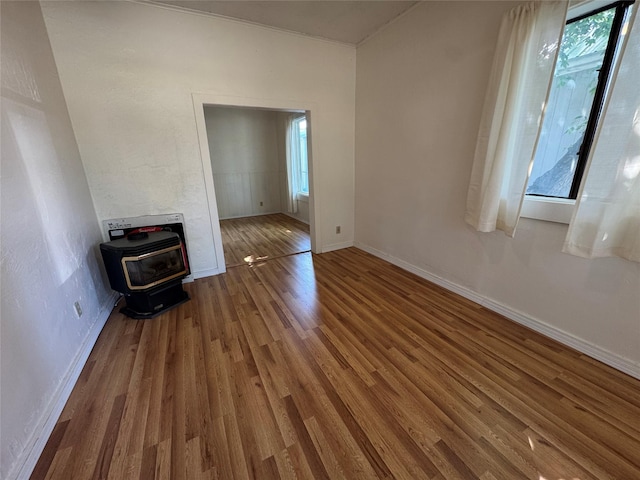108 Meany St, Plains, MT 59859 - spare room featuring a wood stove, wood finished floors, and heating unit