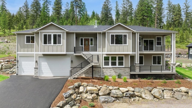 323 Skookum Rd, Lakeside, MT 59922 - view of front of home featuring board and batten siding, covered porch, an attached garage, and stairs