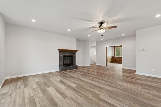 323 Skookum Rd, Lakeside, MT 59922 - unfurnished living room featuring a ceiling fan, light wood finished floors, baseboards, recessed lighting, and a tile fireplace