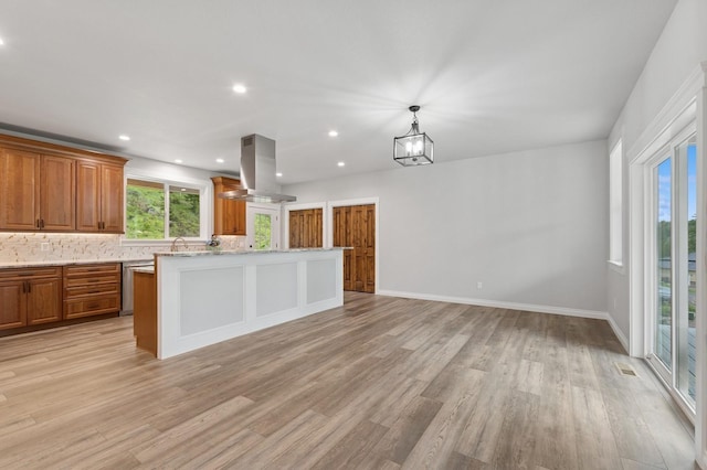 323 Skookum Rd, Lakeside, MT 59922 - kitchen featuring island range hood, brown cabinets, light wood finished floors, a center island, and recessed lighting