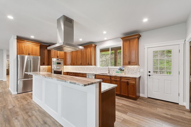 323 Skookum Rd, Lakeside, MT 59922 - kitchen with appliances with stainless steel finishes, island exhaust hood, a center island, healthy amount of natural light, and recessed lighting
