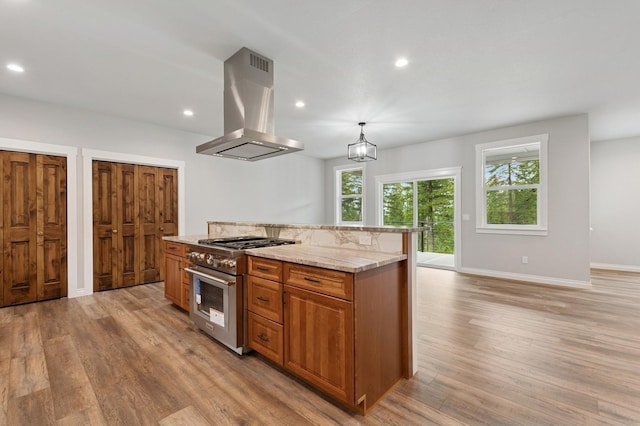 323 Skookum Rd, Lakeside, MT 59922 - kitchen featuring island range hood, high end range, light wood finished floors, brown cabinetry, and recessed lighting