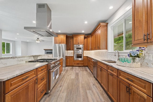 323 Skookum Rd, Lakeside, MT 59922 - kitchen with island exhaust hood, appliances with stainless steel finishes, plenty of natural light, a sink, and recessed lighting