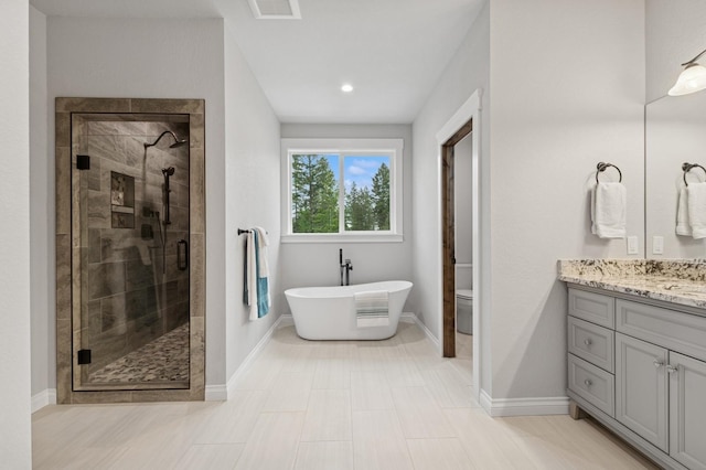 323 Skookum Rd, Lakeside, MT 59922 - full bath featuring a stall shower, vanity, a soaking tub, and baseboards
