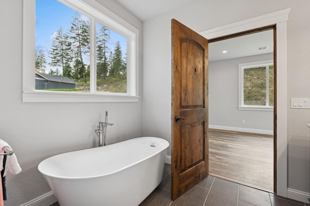 323 Skookum Rd, Lakeside, MT 59922 - bathroom with a soaking tub, baseboards, and wood finished floors