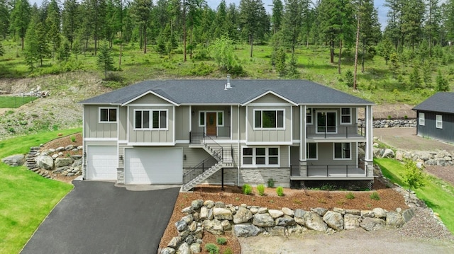 323 Skookum Rd, Lakeside, MT 59922 - view of front of property featuring board and batten siding, a porch, stairs, a garage, and driveway