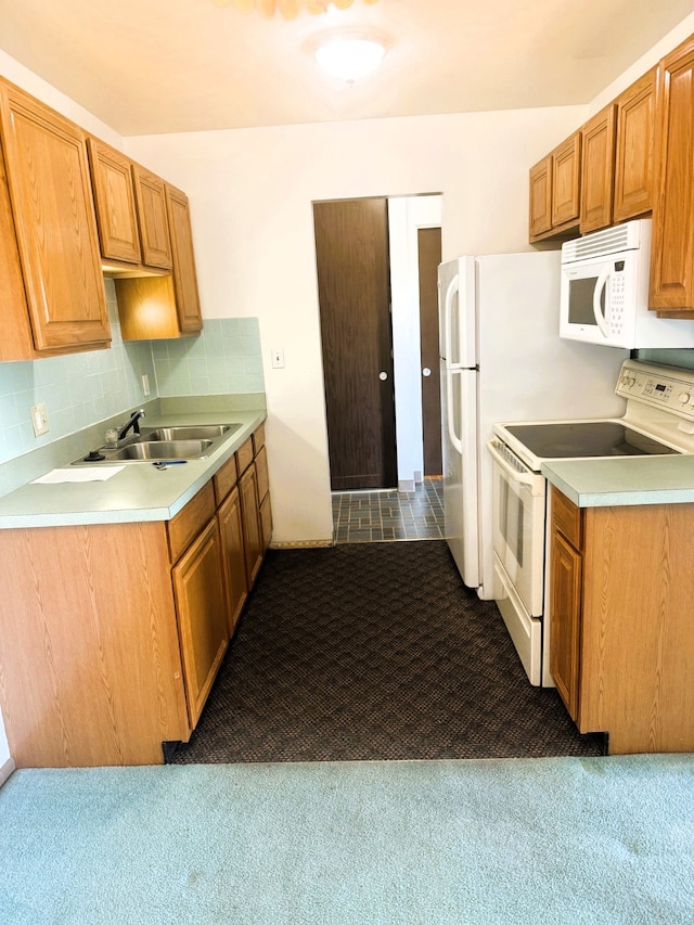 951 Ronald Ave Unit 410, Missoula, MT 59801 - kitchen with white appliances, carpet floors, light countertops, backsplash, and brown cabinets