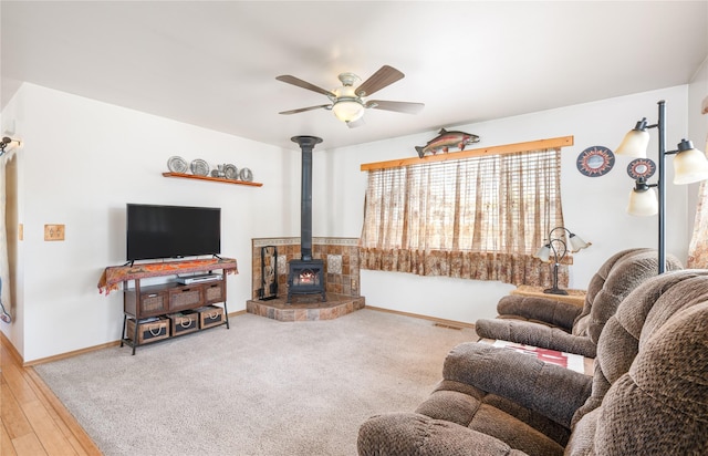 158 Parkside Dr, Kalispell, MT 59901 - living room featuring a wood stove, a ceiling fan, baseboards, and wood finished floors