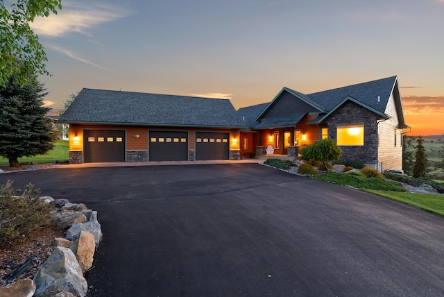 36665 Highland Ct, Polson, MT 59860 - craftsman-style home with stone siding, a garage, and driveway