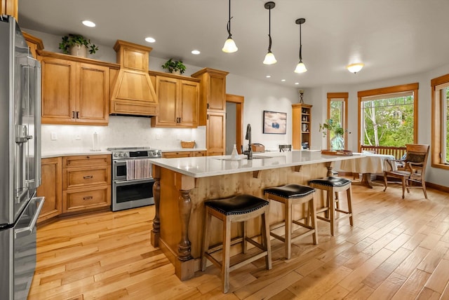 36665 Highland Ct, Polson, MT 59860 - kitchen with appliances with stainless steel finishes, light countertops, light wood-type flooring, a breakfast bar area, and a sink