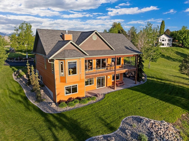 36665 Highland Ct, Polson, MT 59860 - back of house featuring a patio, a yard, a chimney, and a shingled roof