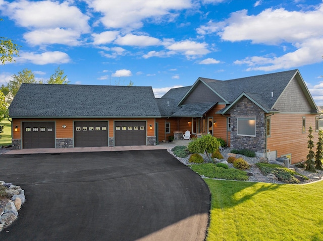 36665 Highland Ct, Polson, MT 59860 - view of front of home with stone siding, a front yard, a porch, an attached garage, and driveway