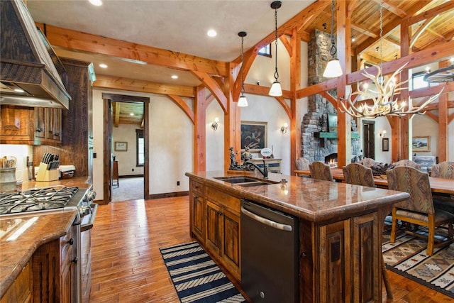 380 Haskill Basin Rd, Whitefish, MT 59937 - kitchen with appliances with stainless steel finishes, custom range hood, open floor plan, beam ceiling, and an island with sink