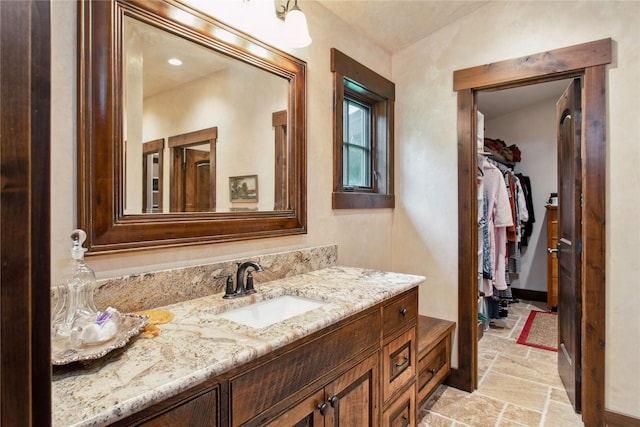 380 Haskill Basin Rd, Whitefish, MT 59937 - bathroom featuring stone tile floors, vanity, and a spacious closet