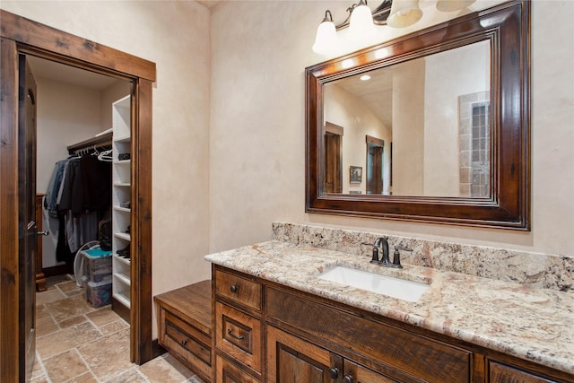 380 Haskill Basin Rd, Whitefish, MT 59937 - bathroom featuring stone tile flooring, vanity, and a walk in closet
